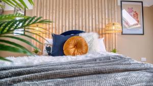 a bedroom with a bed with blue and white pillows at London Acton - hot tub, cinema & gaming room in London