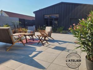 a patio with a table and chairs and a building at L'Atelier in Peuplingues
