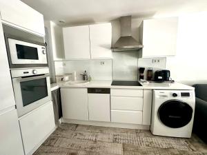 a white kitchen with a sink and a dishwasher at Le Maurice - Air conditioning parking and seaside! in Palavas-les-Flots