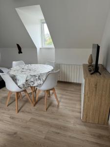 a dining room with a table and chairs at Studio 3ème étage - Centre-ville - Local vélos disponible in Mayenne