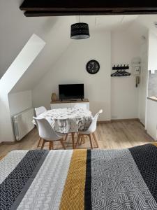 a dining room with a table and chairs at Studio 3ème étage - Centre-ville - Local vélos disponible in Mayenne
