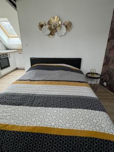 a bedroom with a bed with a black and white comforter at Studio 3ème étage - Centre-ville - Local vélos disponible in Mayenne