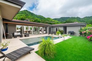 een achtertuin met een zwembad en een gazon bij Contemporary Villa 3 BD 3BA Pool in Playa Flamingo