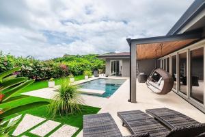 een achtertuin met een zwembad en een huis bij Contemporary Villa 3 BD 3BA Pool in Playa Flamingo