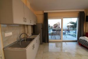 a kitchen with a sink and a view of a patio at NAMARE AQUA in Skala Sotiros