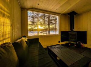 a living room with a couch and a window at Aurora Camp Kiruna in Kiruna