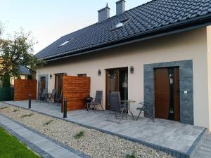 a house with chairs and tables on a patio at Noclegi u Edyty in Zator