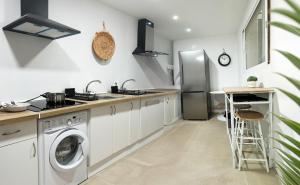 a kitchen with a washer and a stainless steel refrigerator at Costa by Hawkins Algeciras - Exterior 3B in Algeciras +9 photos