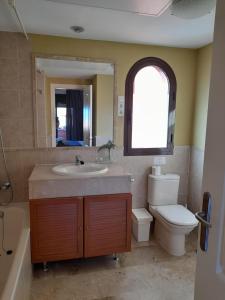 ein Badezimmer mit Waschbecken, Toilette und Spiegel in der Unterkunft APARTAMENTO DUPLEX con piscinas y MARAVILLOSAS VISTAS AL MAR in Estepona