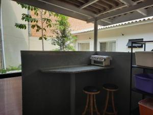 a bar with two stools and a counter top at Studio Pet Friendly 02 in Matinhos