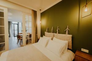 una camera con un letto bianco e una parete verde di Pool House a Tbilisi City