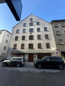 two cars parked in front of a building at 1 bedroom apartment in central Munich in Munich