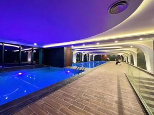 a swimming pool in a building with a purple ceiling at Séjour de luxe à Hải Phòng in Hai Phong