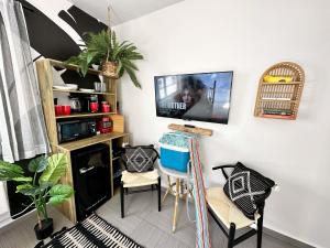 Una sala de estar con un televisor en la pared. en Beachfront Ocean Drive South Beach Miami, en Miami Beach
