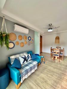 a living room with a blue couch and a table at Apê Vumbora Pra Praia, todo climatizado, a 200 m da praia in Ilhéus