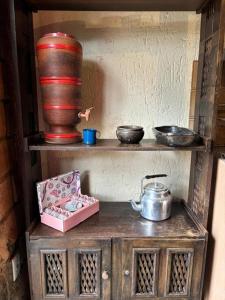 a wooden shelf with pots and pans and a vase at Vila do Salitre - Refúgio Rupestre in Diamantina +15 photos