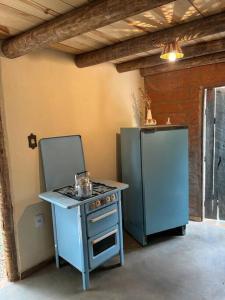 una cucina con fornelli e frigorifero di Vila do Salitre - Chalé a 5 min de lagos e cachoeiras a Diamantina