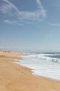 una playa con huellas en la arena y el océano en Maison de Magescq, en Magescq