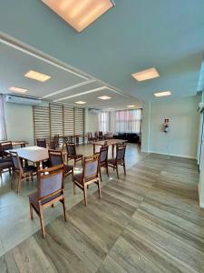 a conference room with tables and chairs and a piano at Apê Vumbora Pra Praia, todo climatizado, a 200 m da praia in Ilhéus +68 photos