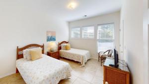 a bedroom with two beds and a flat screen tv at Beach Bum Adventure 2 Bdrm 2 Bath Scenic View in Pawleys Island