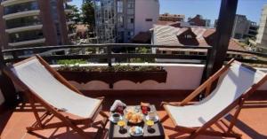 two chairs and a table on a balcony at Hostería Santa Bárbara in Villa Gesell +41 photos