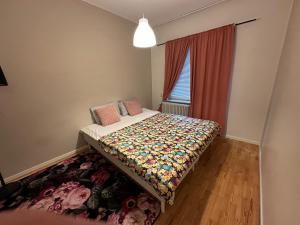a bedroom with a bed with a floral quilt and a window at Apartment Telefonplan Stockholm in Stockholm
