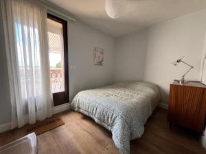 a bedroom with a bed and a window at Les Hirondelles in Saint-Florentin