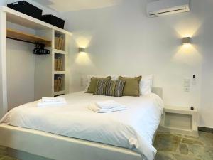a white bed with two towels on top of it at Dryopis Studio in Kithnos