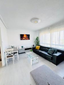 a living room with a black couch and a table at Apartamento en Santander in Santander +8 photos