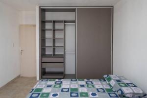 a bedroom with a bed and an open closet at Dúplex Nuevo - Salta Capital in Salta
