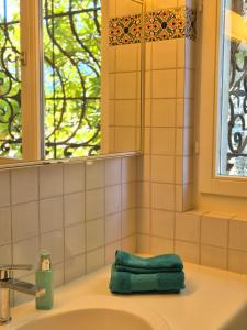 Seefront Villa in Ascona - Lago Maggiore, Ticino في أسكونا: منشفة خضراء موضوعة على حوض في الحمام +35 صورة