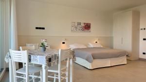 a bedroom with a bed and a table and chairs at Appartamenti Annachiara in Costermano sul Garda