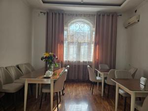 a dining room with tables and chairs and a window at GUESTO HOSTEL in Tashkent