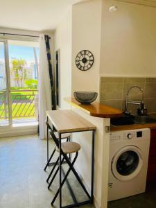 a kitchen with a sink and a washing machine at Le Catelya - Résidence Manganao in Saint-François