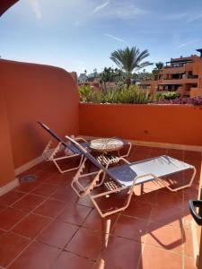 eine Terrasse mit einem Tisch und einem Laptop darauf in der Unterkunft APARTAMENTO DUPLEX con piscinas y MARAVILLOSAS VISTAS AL MAR in Estepona