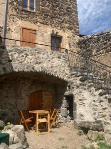 a stone building with a wooden table in front of it at maison de vigneron in Mareugheol