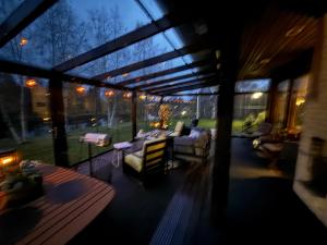 a screened in porch of a house with chairs and tables at Riverside Villa Aurora in Rovaniemi