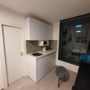 a small kitchen with a sink and a microwave at Ryo 19 דירה במלון בוטיק 2 דקות מטיילת בת ים in Bat Yam