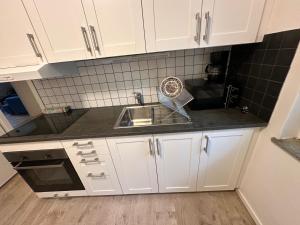 a kitchen with white cabinets and a sink at Apartment Telefonplan Stockholm in Stockholm +13 photos