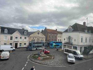 una ciudad con autobuses y coches estacionados en un estacionamiento en Town centre apartment with parking, en Wallingford 4 fotos más