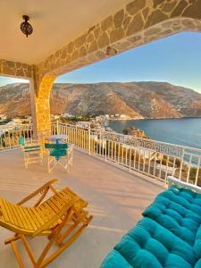 a balcony with chairs and a table and a view of the water at Kalimera Apartment in Kalymnos