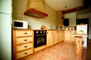 a kitchen with a stove and a microwave at El Rincon del nogal in Tejadillos