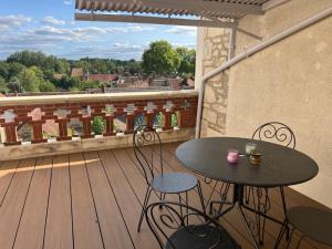 a balcony with a table and chairs on a deck at Les Hirondelles in Saint-Florentin +2 photos
