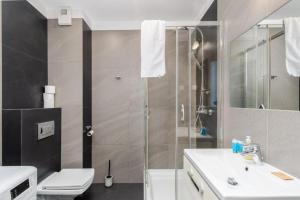 a bathroom with a shower and a toilet and a sink at Borkowska Corner in Kraków +4 photos