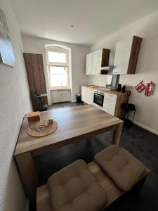 a kitchen with a wooden table and chairs in it at Wohnen in Loriots Wasserstadt mit Kamin und MagentaTV in Brandenburg an der Havel