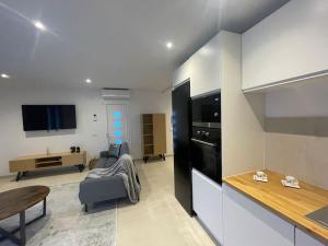 エンプリアブラバにあるVilla moderna piscina privadaのソファとテーブルのあるキッチンとリビングルーム