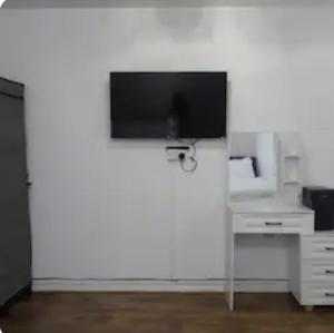 a flat screen tv hanging on a white wall at Kingdom Residence in Manchester