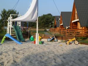 einen Spielplatz mit Spielzeug im Sand vor einem Haus in der Unterkunft Cicha Przystań in Sasino