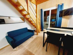 a living room with a blue couch and a table at LE COSY à Aime La Plagne in Aime-La Plagne