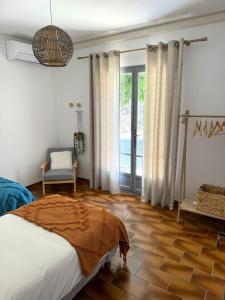 a bedroom with a bed and a large window at La Douceur des Alpilles in Saint-Rémy-de-Provence +9 photos